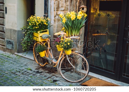 Bicycle with a yellow flower basket next to a modern cafe