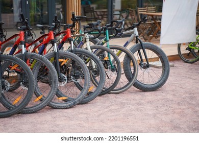 Bicycles Stand By The Building. Bicycles For Rent.