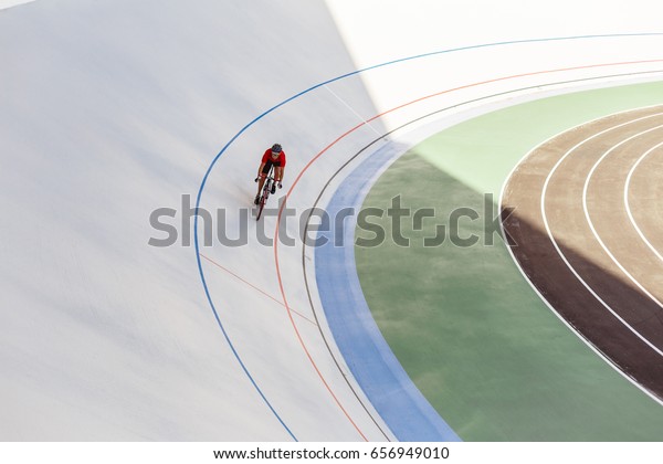 Bicyclist on cycle track outdoor. Active man\
racing at white\
velodrome.