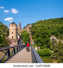Bicyclist on wood bridge in front of  castel of Wertheim am Main, Germany.