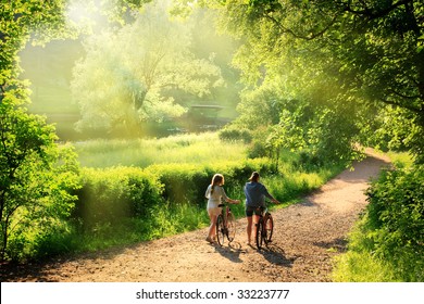 Bicyclists walk in the park with their bikes - Powered by Shutterstock