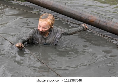 Biddinghuizen, The Netherlands - June 23, 2018: Child During A Mud Run (mudraise, Charity) In The Mud And In The Black Water.