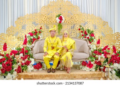 Bidor,Perak,Malaysia - February 2022.Photo Of The Groom And Bride Wearing Traditional Yellow Malay Wedding Dresses At The Wedding,happy Family Concept