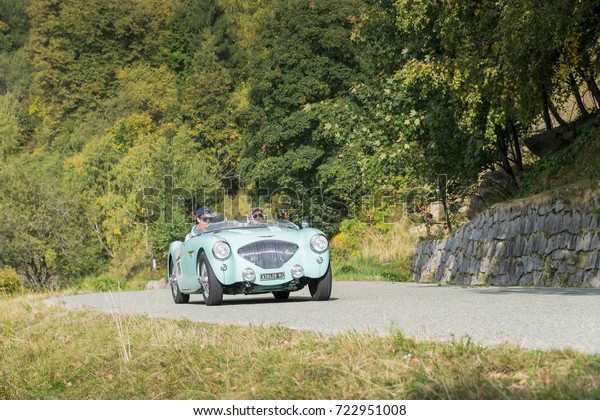 BIELLA / ITALY - SEPTEMBER 24,\
2017: Vintage car running on country road: an Austin Healey 100/4\
during a meeting of historic cars. This model was built in\
1955.