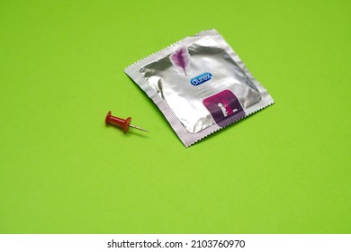 Bielsko, Poland - 01.10.2022: a pin next to a Durex condom. Concept showing a leaky condom.