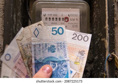 Bielsko, Poland - 12.07.2021: Polish Money Next To The Gas Or Electricity Meter. Increases In Gas And Electricity Prices In Poland. Rising Inflation