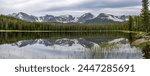 Bierstadt Lake - A panoramic view of rugged high peaks reflecting in calm Bierstadt Lake on a stormy Spring morning. Rocky Mountain National Park, Colorado, USA.