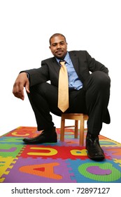 Big African American Businessman Sitting On Small Chair Over White Background.