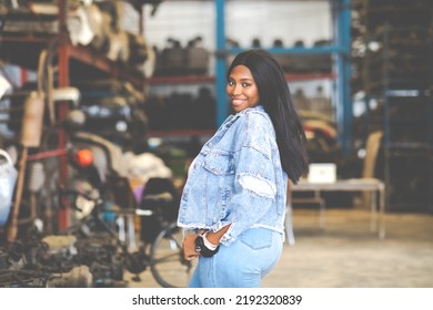 Big African American Woman Modeling. Old Machine Auto Parts In Warehouses. Auto Mechanic Car Service, Repair And Maintenance Concept. Used Car-auto Mobile Spare Parts