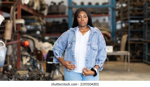 Big African American Woman Modeling. Old Machine Auto Parts In Warehouses. Auto Mechanic Car Service, Repair And Maintenance Concept. Used Car-auto Mobile Spare Parts