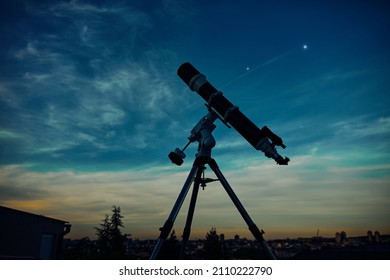 Big astronomical telescope under a twilight sky ready for stargazing.