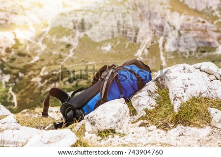 Big backpack lying on the ground in the mountain background. 