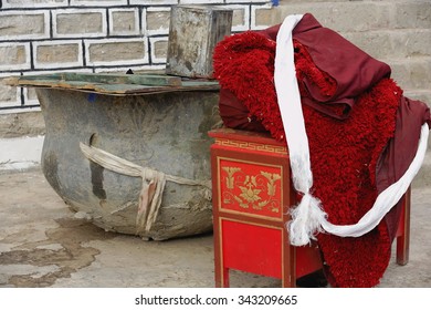 Big basin-red side table and robe-concrete floor and wall. Nunnery on Ponpori Hill-right bank of Trum or Chong Chu river-grounds of the 1073 AD-Khon Konchog Gyalpo built Sakya-Grey Soil monast. Tibet.