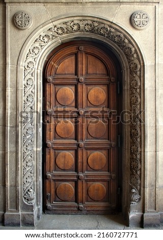 big beautiful ornate wooden door, framed by a decorated stone arch - entrance to a gothic cathedral or castle