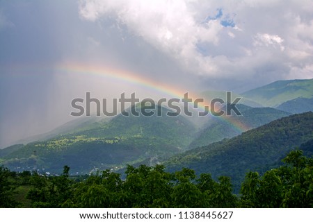 A big beautiful rainbow after a rain on a background of mountains, forests and mist in Dilijan, Armenia