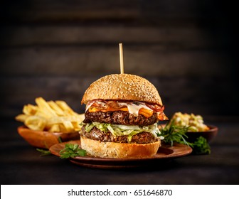 Big Beef Burger With Melted Cheese And Bacon On Wooden Plate