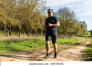 Big Belly Man Jogging - Exercising, Doing Cardio In The Park - Slightly Overweight  Loosing Weight - Young Overweight Man Running Outdoors - Fat Man Running