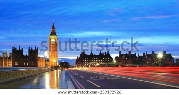Big Ben and London at night with the lights of\
the cars passing by after rain, the most prominent symbols of both\
London and England
