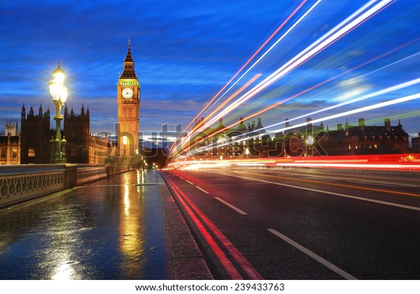 Big Ben and London at night with the lights of\
the cars passing by after rain, the most prominent symbols of both\
London and England