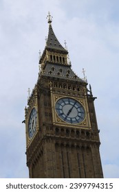 Big Ben tower in London United Kingdon UK, with red buses, fags and people