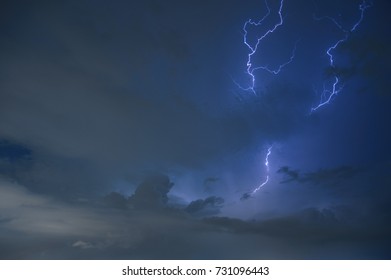 The big black dramatic rain clouds come with the lightning strike as the thunder roll at night heavy thunder-storm over the city. (Selective focus)
