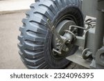 Big black wheel of military equipment. Wheel on a green support with brakes.