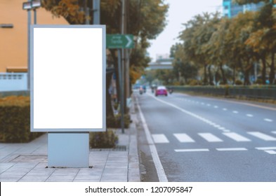 big blank billboard white LED screen vertical outstanding in the city on pathway side the road traffic for display advertisement text template promotion new brand at outdoor with green tree. - Powered by Shutterstock