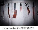 Big bloody knife and kitchen items hanging on the wall in blood.Halloween.