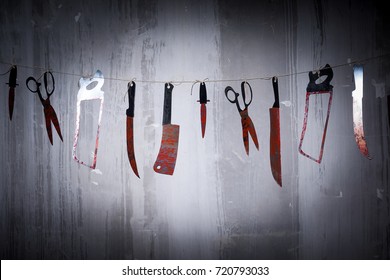 Big bloody knife and kitchen items hanging on the wall in blood.Halloween.