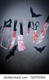 Big bloody knife and kitchen items hanging on the wall in blood.Halloween.