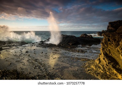 Big blow hole spraying ocean mist into the air in Hawaii on the Island of Oahu