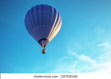 Big Blue Hot Air Balloon Flying In Light Blue Sky With Copy Space. Large Ballon Riding, Ballooning Festival