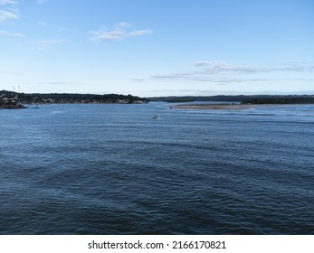 Big Blue River With Tree-lined Beach On The Horizon