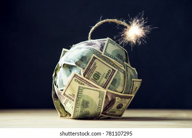 Big bomb of money hundred dollar bills with a burning wick. Little time before the explosion. The concept of financial crisis
