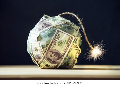 Big bomb of money hundred dollar bills with a burning wick. Little time before the explosion. The concept of financial crisis