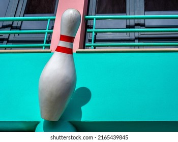 A Big Bowling Pin On A Green Wall