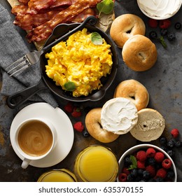 Big Breakfast With Bacon, Bagels And Scrambled Eggs On The Table Overhead With Copy Space