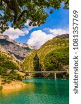 Big bridge across the cliffs of Verdon Canyon, France. The picturesque . Brightly green river water. The concept of active and ecotourism