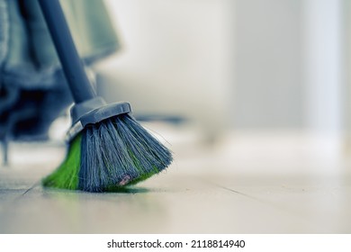 Big broom for wooden floor cleaning standing in light room at home or office building indoor closeup. Cleanup service conception.
