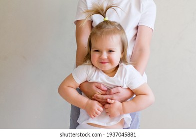 Big Brother Hands Holding Cute Toddler Sister At Home. Child In White T-shirt Playing, Having Fun, Hugging, Smiling. Sibling Bond And Relationship.  International Day Of Brother And Sister.