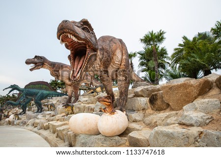 big brown dinosaur statue on the rock in the park asia Thailand