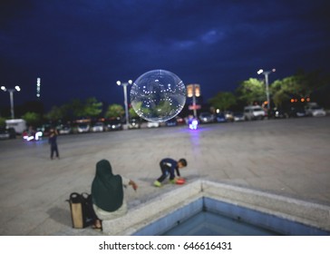 big bubble floating around while kids play in a park