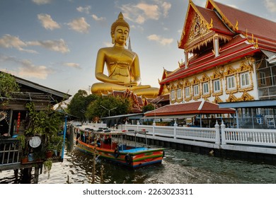 Big Buddha Dhammakaya Tep Mongkol Buddha of Paknam Bhasicharoen temple in Thonburi in Bangkok city against the backdrop of sunset and canal