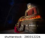 Big buddha statue and Mini Monk in meditation inside temple in Bagan Mandalay Myanmar