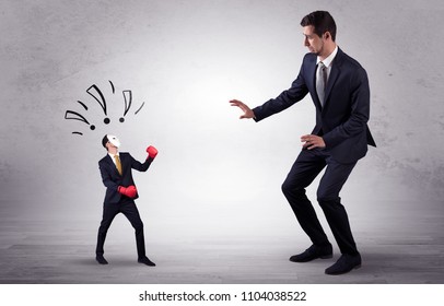 Big Businessman Being Afraid Of Small Masked Businessman With Box Gloves In An Empty Room Concept