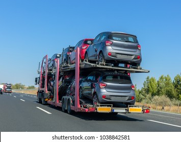 Big car carrier trailer with cars on bunk platform. Car transport truck on the highway