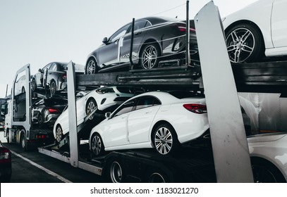 Big Car Carrier Truck Of New Luxury Sport  German Cars For Batch Delivery To Dealership . Full Load Transport Truck Of New Powerful New Vehicles. Automotive Industry  Rent  Shipping Background.