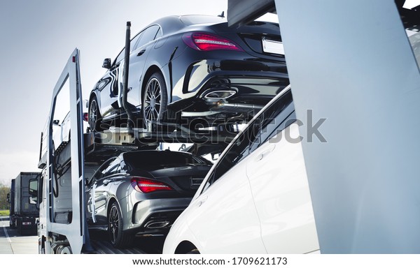 Big car carrier truck of new luxury sport
german cars  delivery to dealership . truck of new powerful  new
vehicles. Car detailing : Glass coating Automotive industry buy 
rent  shipping background.