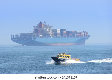 Big Cargo ship with fast small boat - Powered by Shutterstock