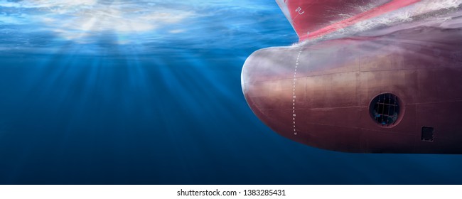 Big cargo ship sailing in the sea to Shipping container terminal. Close up image detail ships bow, underwater view. Shipping business and underwater survey concept. Hull maintenance and inspection.